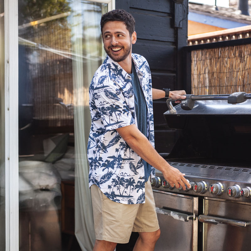 Man lighting grill on porch.